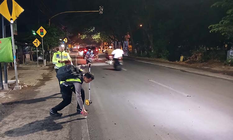 Petugas saat melakukan olah TKP kecelakaan maut di Wonorejo hingga membuat seorang pemotor tewas.