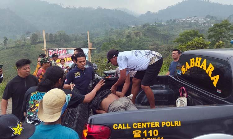 Petugas dibantu warga saat mengevakuasi terduga pencuri motor yang dimassa warga.