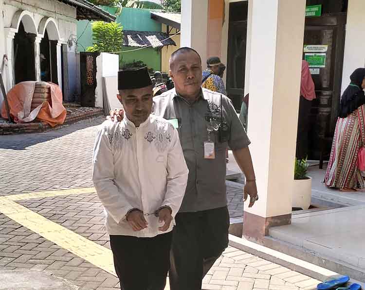 DIGELANDANG: Sl dikawal petugas keamanan Kejaksaan Negeri Kabupaten Probolinggo menuju ruang persidangan di PN Kraksaan.