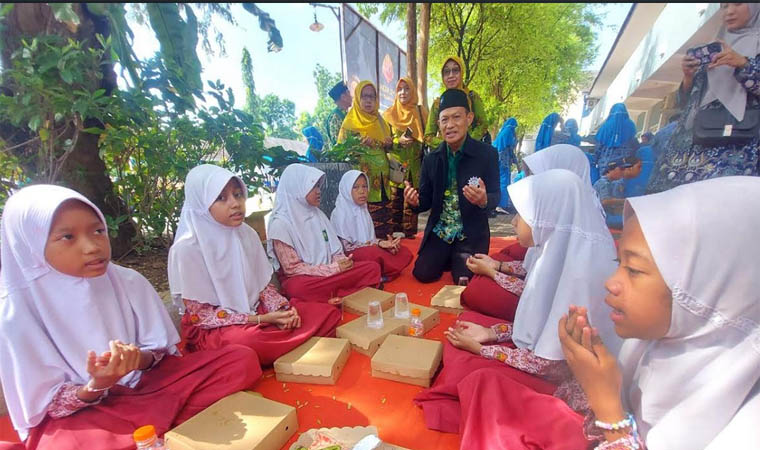 WUJUD SYUKUR: Pimpinan Daerah Muhammadiyah (PDM) Kota Pasuruan H. Abu Nasir, M.Ag Berdoa bersama pelajar sebelum makan paket bergizi gratis yang diberikan pada Milad Mummadiyah ke-112 Senin (18/11).