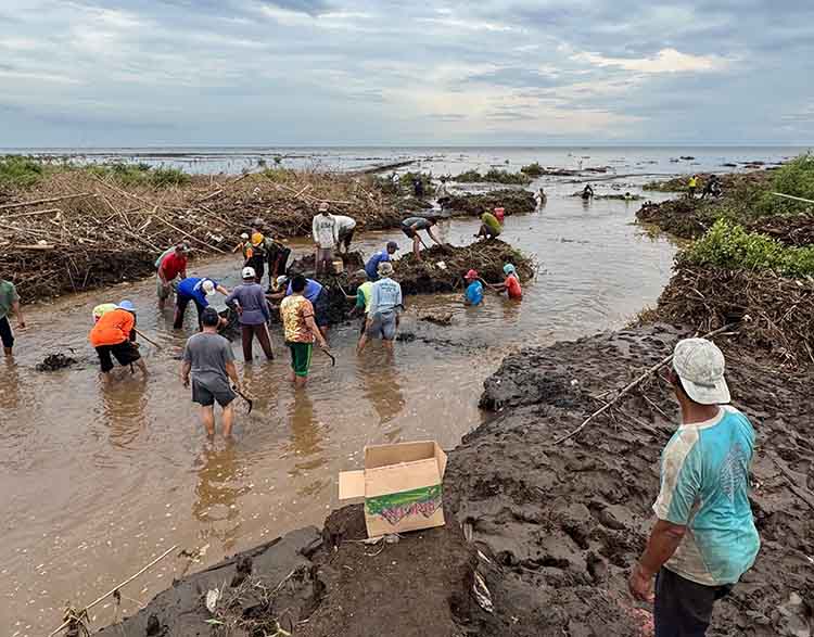 KERJA BAKTI: Sejumlah warga bersama BPBD Kabupaten Probolinggo-Pasuruan membersihkan muara Sungai Laweyan, Desa Tambakrejo, Kecamatan Tongas, Minggu (1/12).