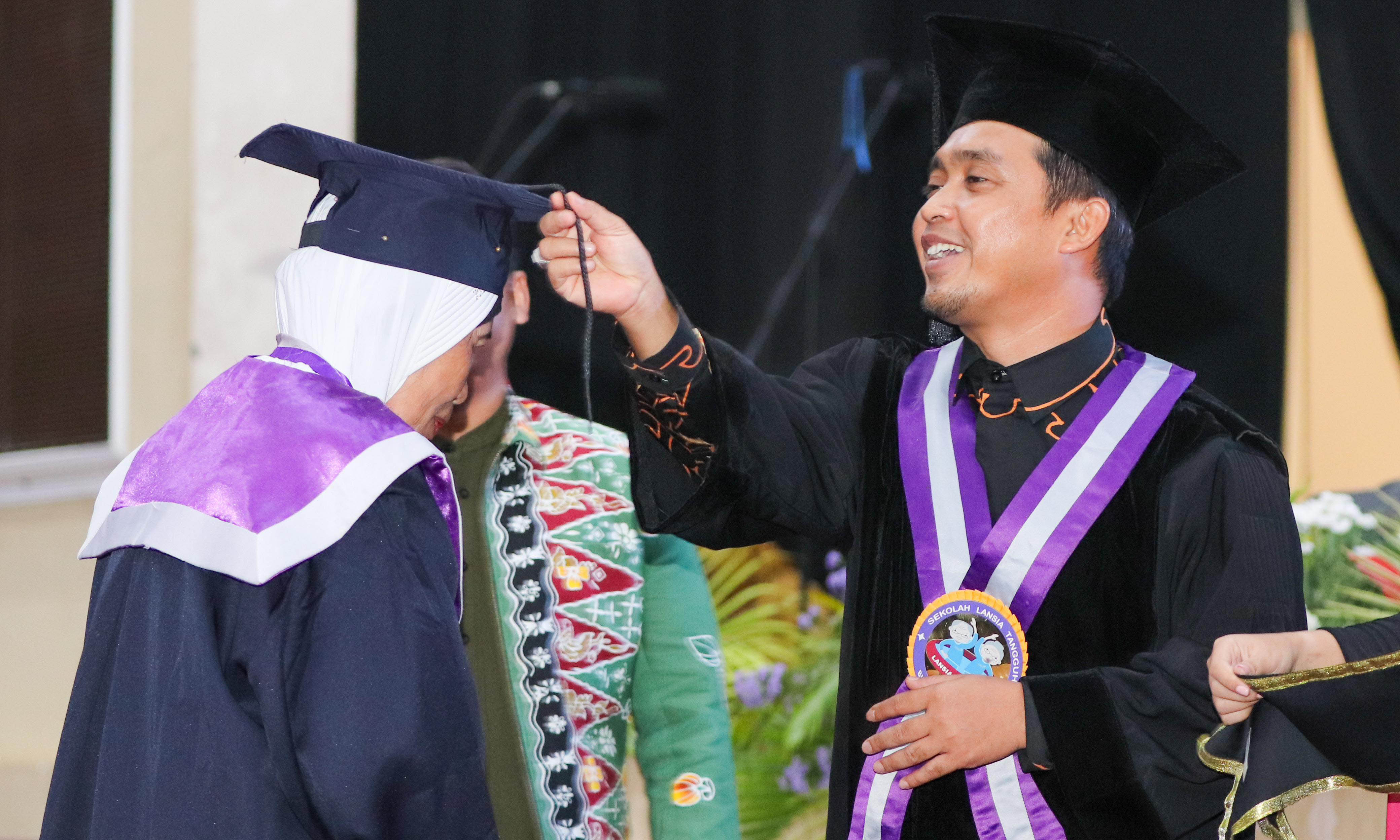 MOMEN SAKRAL: Plt Wali Kota Pasuruan H. Adi Wibowo, S.T.P., M.Si mewisuda lansia yang lulus selantang di Kota Pasuruan. (Dinas Kominfotik for Radar Bromo)