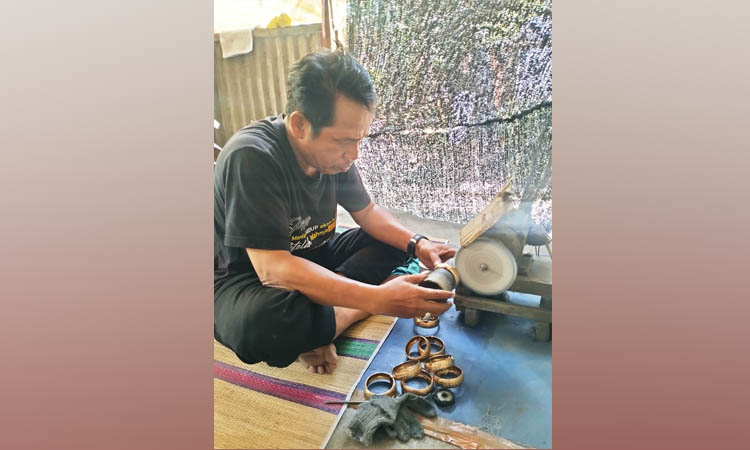 BAHAN CAMPURAN: M Yunus melakukan proses memoles saat membuat kerajinan perhiasan mamasan di rumahnya.