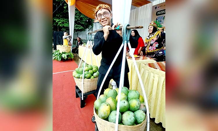 PIKUL MANGGA: Usai mengunjungi pameran berbagai macam varietas Mangga dan icipan secara gratis, Pj. Wali Kota M. Taufik menyempatkan diri berpose sambil memikul kranjang Mangga.