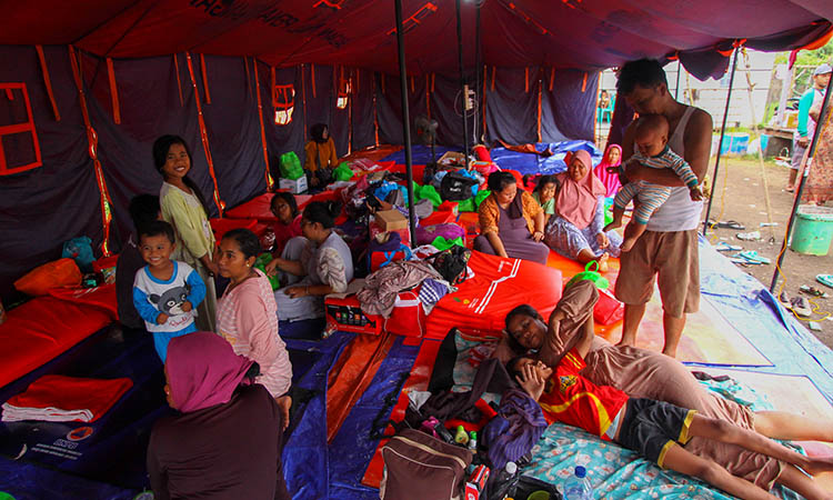 NGUNGSI: Warga Desa Jarangan, Kecamatan Rejoso yang tinggal sementara di tenda pengungsian. Sebagian dari mereka memilih pulang, untuk bersih-bersih rumah. Dan akan kambeli, ketika cuaca tak kondusif.