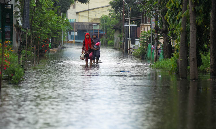 MENGGENANG: Banjir yang masih menggenangi wilayah Rejoso Lor, Kecamatan Rejoso. Tampak pejalan kaki melintasi genangan air.