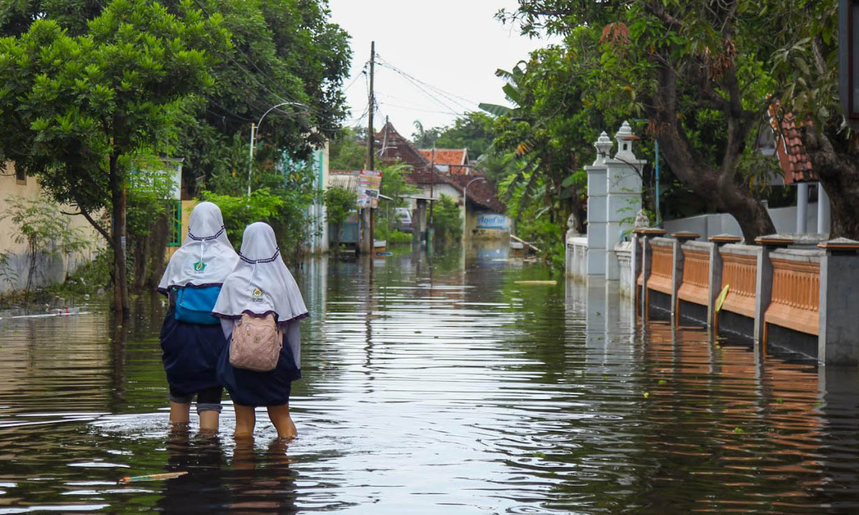 TAK PAKAI SEPATU: Siswi di Rejoso Lor yang harus berjalan di genangan saat banjir melanda, Minggu (8/12) lalu. Sebagian siswa bahkan ada yang tak sekolah karena ban