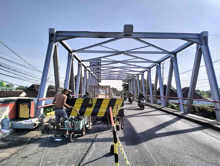 DIPERBAIKI: Pekerja memperbaiki Jembatan Pajarakan, Kabupaten Probolinggo, yang rusak Selasa (10/12).