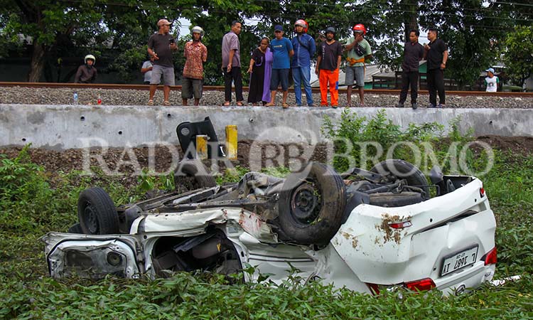 TERBALIK: Kondisi mobil Avanza yang terbalik usai tertemper KA Sri tanjung di perlintasan sebidang Rejoso, Kabupaten Pasuruan. (Mokhamad Zubaidillah/ Radar Bromo)