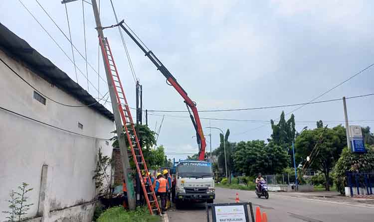 DIGALI: Petugas PLN ULP Probolinggo saat melakukan perbaikan tiang miring di Jalan Anggrek, Kelurahan Pilang, Kecamatan Kademangan, Kota Probolinggo, Minggu (15/12).