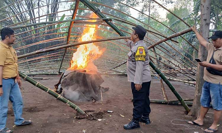 DIBAKAR: Petugas saat memusnahkan sejumlah barang bukti di arena sabung ayam Karangrejo, Gempol, Kabupaten Pasuruan.
