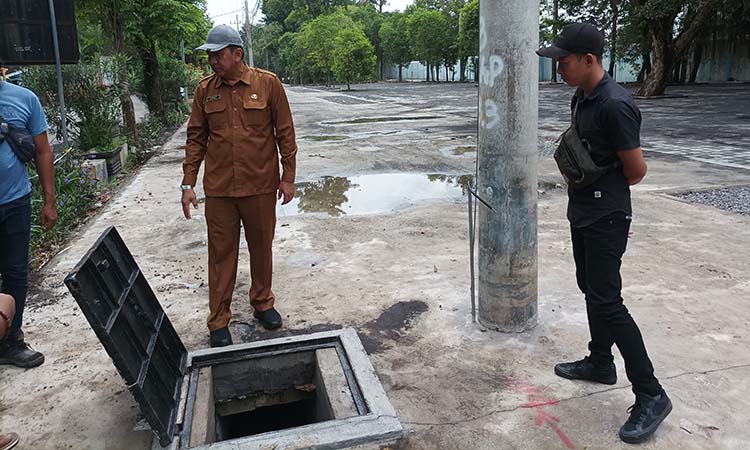 CEK IRIGASI: Kepala DPKPP Roby Siswanto mengecek saluran irigasi di timur Jalan dr. Soetomo Stadion GMK. Saluran ini ditenggarai juga menjadi penyebab banjir genangan di Jalan dr Soetomo.