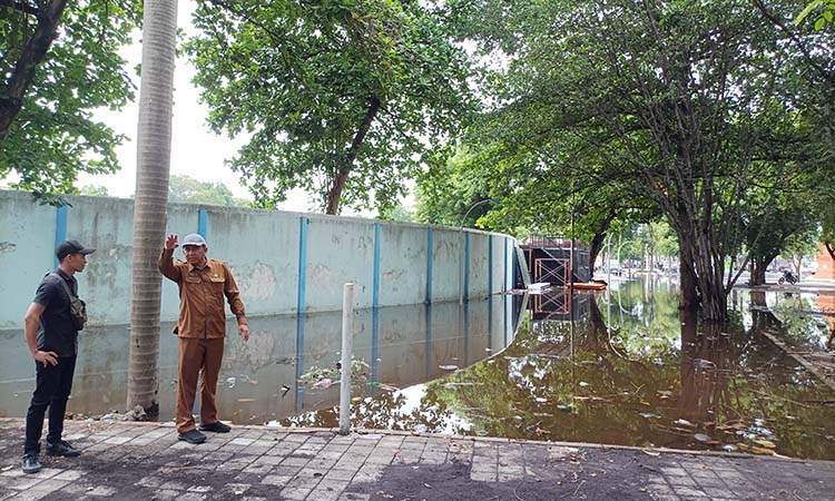 CEK GENANGAN: Kepala DPKPP Kabupaten Probolingog Roby Siswanto mengecek genangan di wilayah Stadion GMK. Hingga Senin (16/12) banjir genangan masih terjadi di sekitar stadion. (Agus Faiz Musleh)