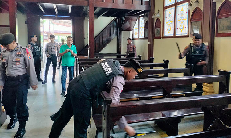 STERIL: Petugas Polres Pasuruan Kota saat melakukan strerilisasi gereja di wilayah Kota Pasuruan. Hal ini sebagai antisipasi jelang Natal. Agar jemaat bisa beribadah dengan aman dan khusuk.