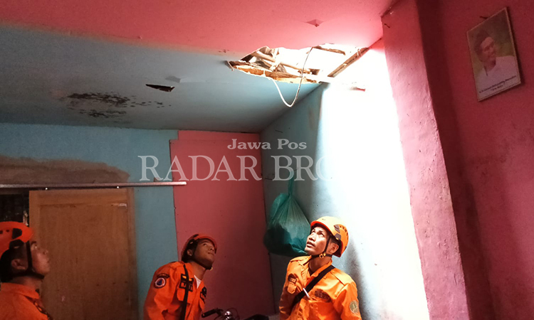 LAPUK: Petugas BPBD Kota Pasuruan saat mengecek kondisi rumah Siti Djubaidah di Gadingrejo yang atapnya ambrol.