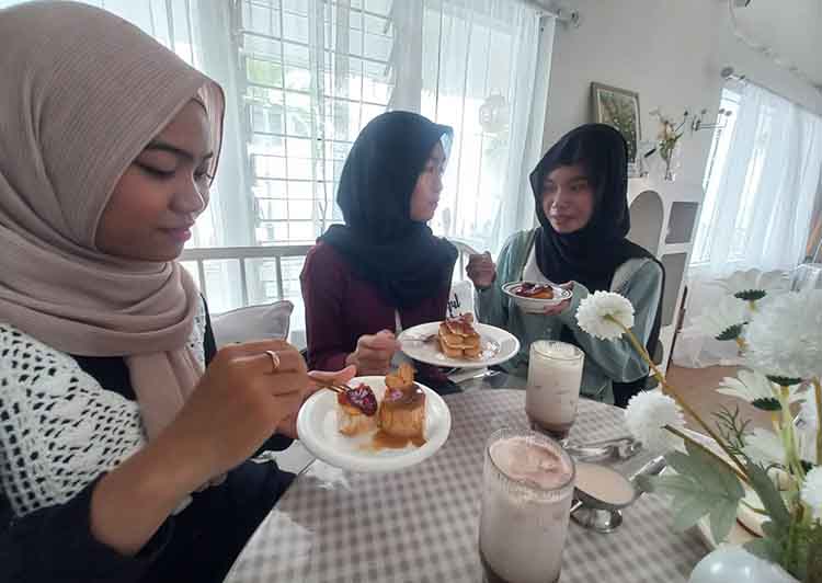 SENANG: Medina Ariyanti, warga Kelurahan Jrebeng Kulon, Kecamatan Kedopok, menikmati cake estetik ala Korea.