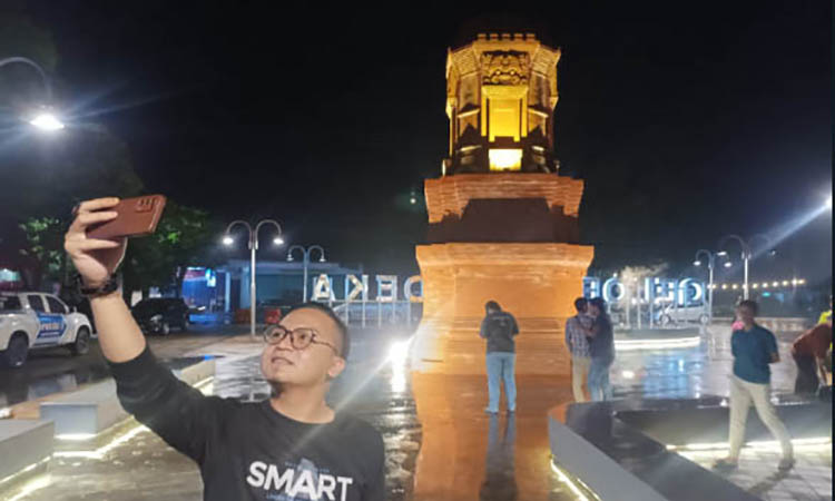 SELFI: Salah satu pengunjung di Stadion Gelora Merdeka mengabadikan momennya dengan latar belakang Candi Jabung.