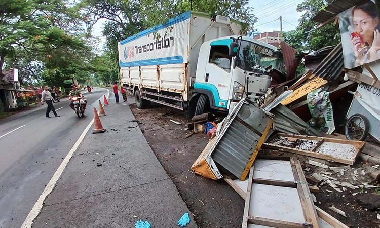 HILANG KENDALI: Kondisi truk boks usai menabrak motor dan warung di Purwosari, Kabupaten Pasuruan.