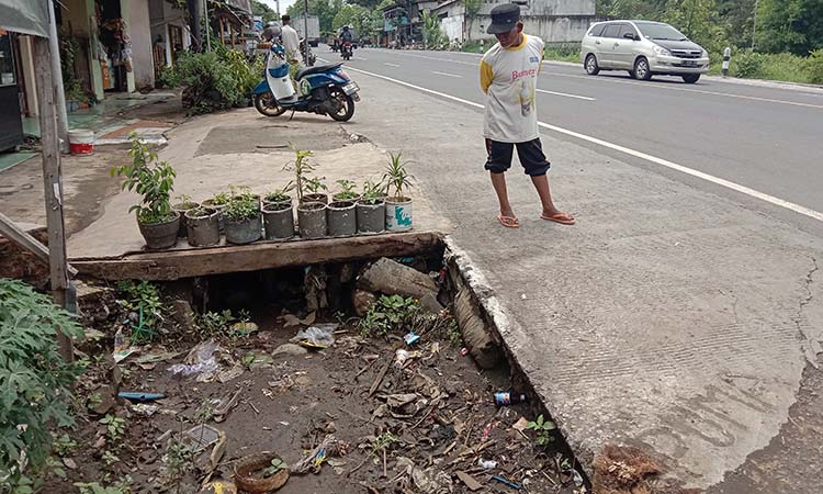 MEMBAHAYAKAN: Saluran air tanpa penutup di pertigaan Tegalsiwalan ini beberapa kali makam korban. Beberapa pengendara jatuh ke saluran ini selama setahun.