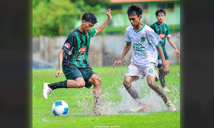 HUJAN-HUJANAN: Laga antara Pasuruan United dan PS Surabaya Muda yang digelar di Stadion Jenggolo, Sidoarjo, Minggu (5/1) sore. Nampak Nur Ari Syarifuddin (kiri) berjibaku dengan genangan air