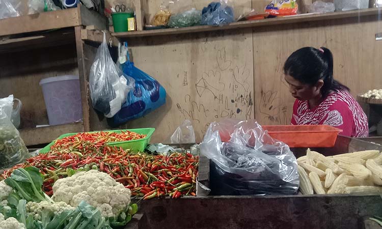 PUSING: Maimunah, 40, pedagang Pasar Baru Kota Probolinggo mengeluhkan turunnya pembeli akibat harga cabai melambung.