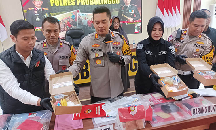 DUKUNG MBG: Kapolres Probolinggo AKBP Wisnu Wardana memperlihatkan salah satu menu yang diberikannya kepada siswa dalam program makan bergizi gratis yang dilakukan swadaya oleh Polres Probolinggo.