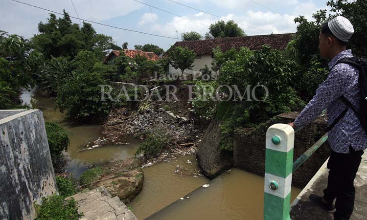 AMBROL: Plengsengan Sungai Legundi ambrol sepanjang 15 meter di Jalan Kiai H. Fadhol, Kelurahan/Kecamatan Kademangan, Kota Probolinggo. (Zainal Arifin/ Radar Bromo)