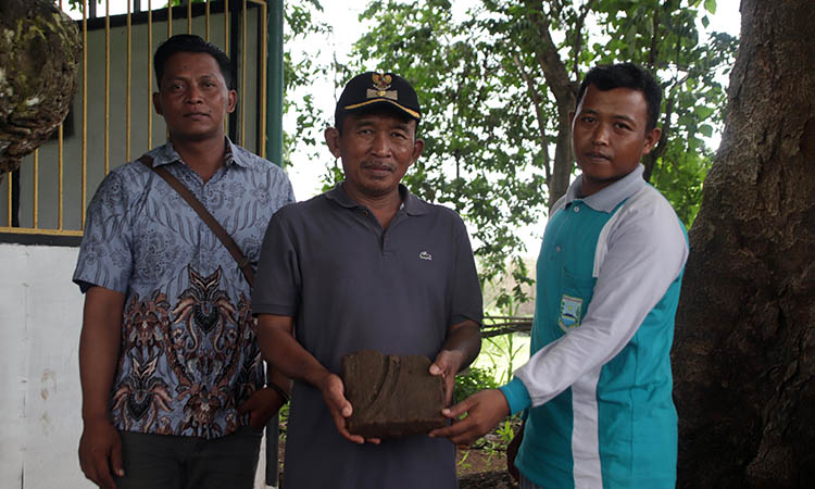 SISA: Kepala Desa Sidorejo, Kecamatan Kotaanyar, Jamhur (bertopi) menunjukkan bata yang tersisa. Konon, mereka percaya batu bata di Dusun Pagar Bata, Desa Sidorejo itu, merupakan peninggalan sejarah.