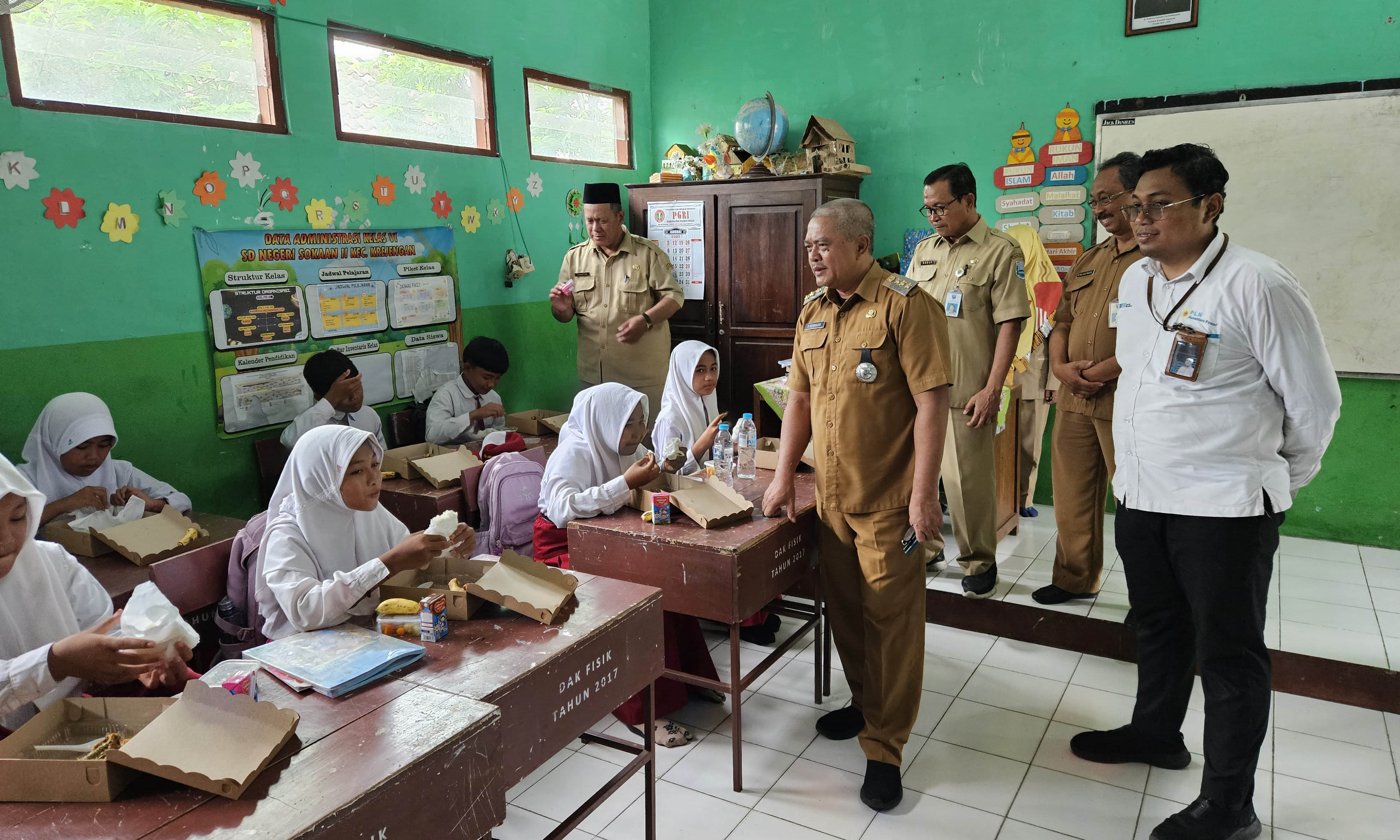 MENGAWALI: Asisten Pemerintahan dan Kesra Pemkab Probolinggo Bambang Heriwahjudi (dua dari kanan) saat memantau langsung pemberian MBG, SDN Sokaan II, Kecamatan Krejengan, Senin (13/1).