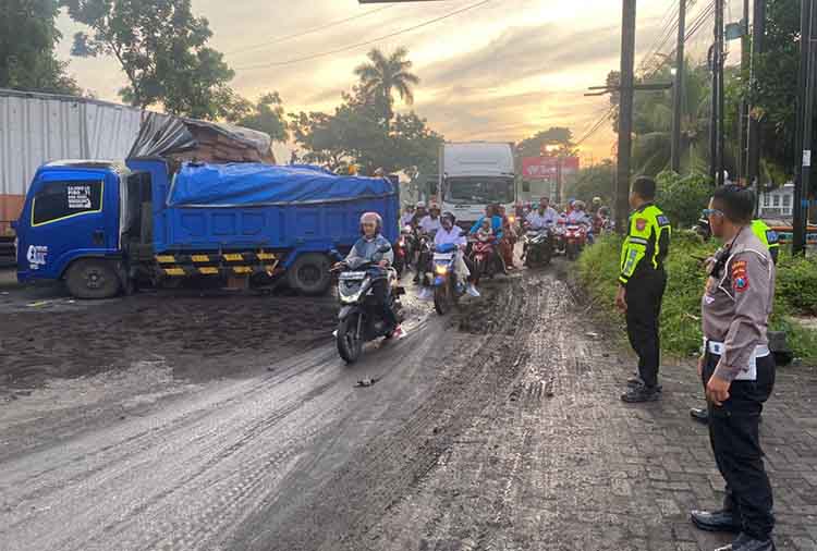 MACET: Anggota Satlantas Polres Probolinggo Kota mengatur arus lalu lintas di lokasi kecelakaan truk di Jalan Pantura, Desa Banjarsari, Kecamatan Sumberasih, Kabupaten Probolinggo, Rabu (15/1).