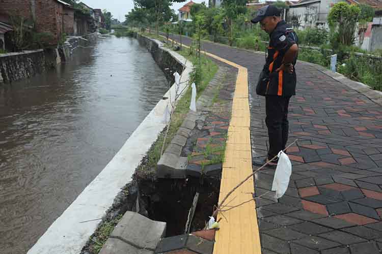 RUSAK: Seorang warga mengamati Jalan Tembus Gladak Serang-Maramis, yang jebol Kamis (16/1). Dinas PUPR PKP Kota Probolinggo berjanji akan segera memperbaikinya.