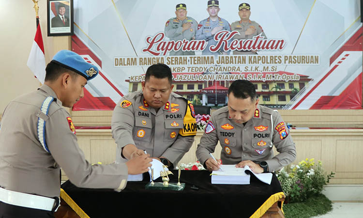TANDA TANGAN: AKBP Teddy Chandra (kanan) dan AKBP Jazuli Dani Iriawan (tengah) saat membubuhkan tandan tangannya pada kegiatan Laporan Kesatuan dalam Sertijab di Mapolres Pasuruan, Rabu (15/1).