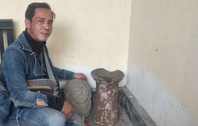TUNGKU TANAH: Anggota Komunitas PJSP menunjukkan salah satu barang temuannya berupa tungku. Tungku ini ditemukan di Winongan dan disebut peninggalan zaman kerajaan Majapahit.