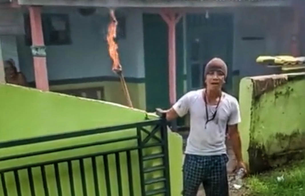BIKIN ULAH: Agus saat mengancam membakar rumah warga Bulu, Kecamatan Kraksaan.