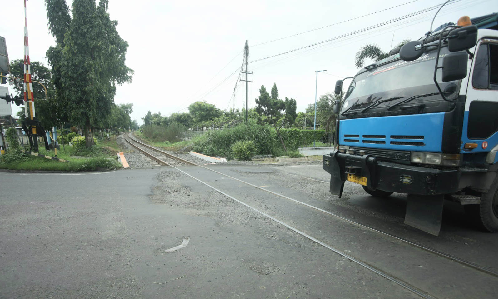 BAHAYAKAN PENGENDARA: Perlintasan Kereta Api di Pilang yang aspalnya rusak dan berlubang.