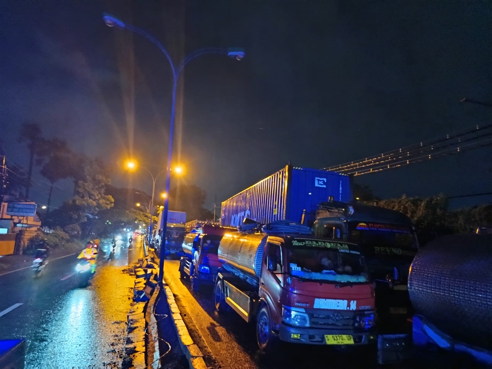 MACET: Sejumlah kendaraan besar terjebak macet usai sebuah truk kontainer terguling malang melintang di ruas jalan nasional Surabaya-Malang, di Sumberejo, Pandaan, Kamis (23/1) malam. (Rizal Syatori)