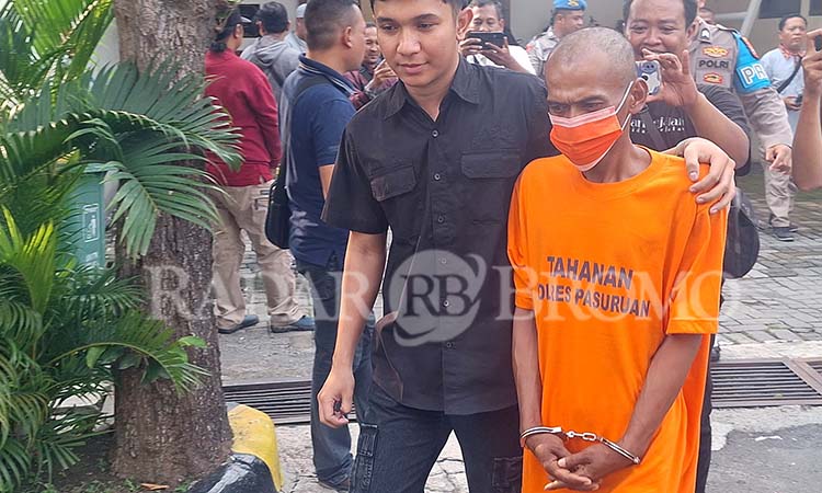 RAJA TEGA: Sugiantoro, mengenakan baju tahanan saat dikeler petugas Polres Pasuruan.