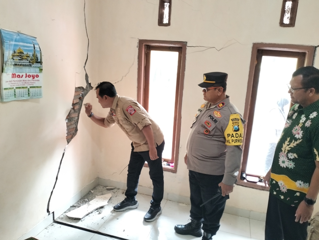 Pj Bupati Pasuruan Nurkholis saat mengecek salah satu rumah warga yang alami retak imbas bencana tanah bergerak. (Rizal Syatori/ Radar Bromo)