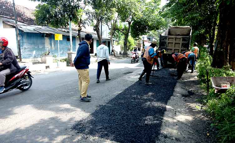 DIPERBAIKI: Sejumlah pekerja memperbaiki Jalan Brantas, Kota Probolinggo. terlihat Kabid Bina Marga Gigih Adityawan mengawasi langsung pengerjaannya.