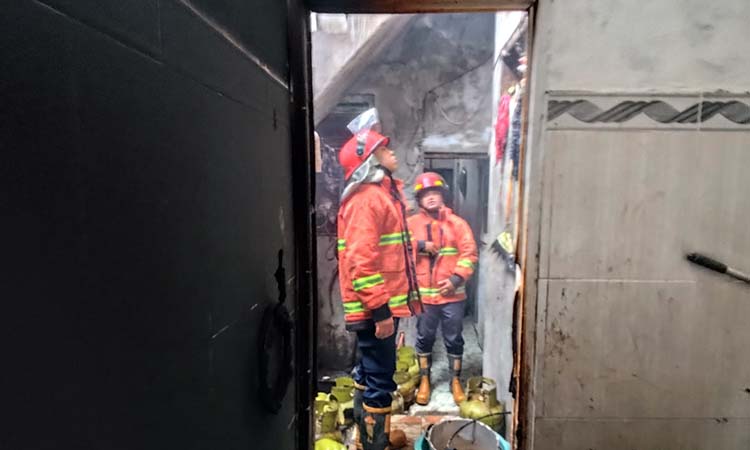 AMUK SI JAGO MERAH: Petugas damkar saat mengecek kondisi dapur warung soto ayam Lamongan di Kebonagung, Purworejo, Pasuruan yang terbakar.