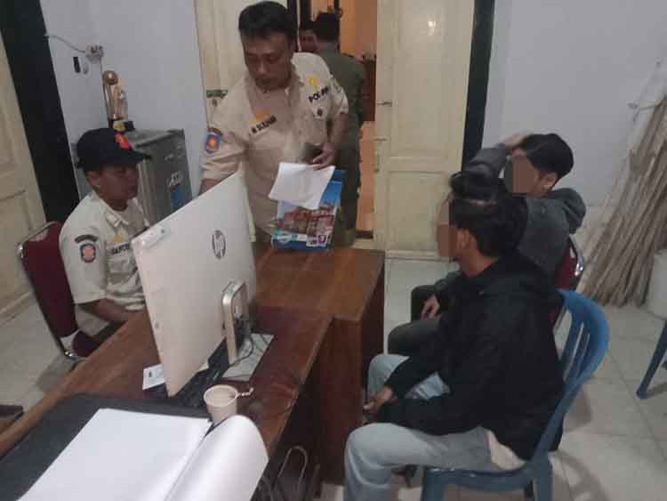 DIAMANKAN: Dua remaja asal Kabupaten Probolinggo diamankan Satpol PP Kota Probolinggo setelah kedapatan mengonsumsi miras di angkringan, Jalan Siaman, Kota Probolinggo, Minggu (9/2) malam.