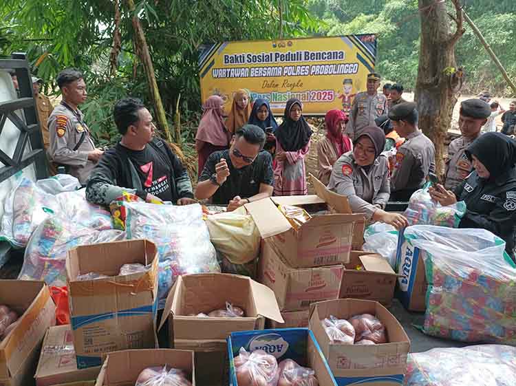 BERBAGI: Sejumlah anggota kepolisian bersama wartawan memberi bantuan sosial kepada warga yang terdampak bencana di Kecamatan Krejengan, Selasa (11/2).