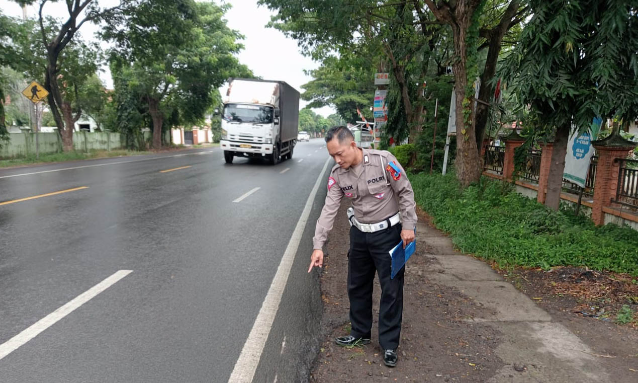 HILANG KENDALI: Anggota Satlantas Polres Probolinggo menunjukkan bekas roda pikap yang turun ke bahu jalan kemudian memicu terjadinya kecelakaan.