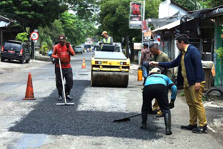 DIGARAP: Sejumlah pekerja menggarap perbaikan Jalan Sunan Ampel, Kota Probolinggo, Selasa (25/2). Perbaikan jalan ini diperkirakan butuh waktu dua pekan.
