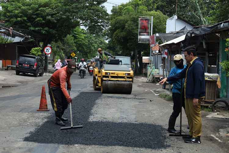 DIGARAP: Sejumlah pekerja menggarap perbaikan Jalan Sunan Ampel, Kota Probolinggo, Selasa (25/2). Perbaikan jalan ini diperkirakan butuh waktu dua pekan.