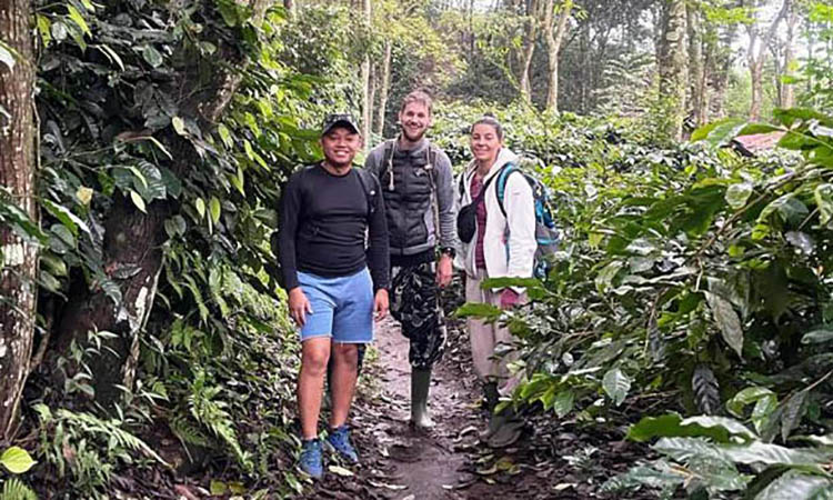 SURVEI KEBUN: Renza Saputra mendampingi peneliti kopi asal Swiss, ke areal perkebunan kopi di Desa Jatiarjo, Kecamatan Prigen.