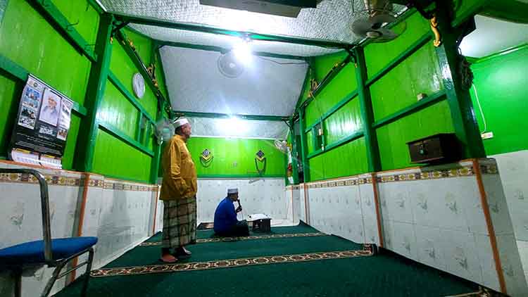 TETAP LESTARI: Pengelola Musala Muhammad Yasin, Abdul Agil Haneman (berdiri) bersama salah seorang warga sedang tadarus di Musala Muhammad Yasin.