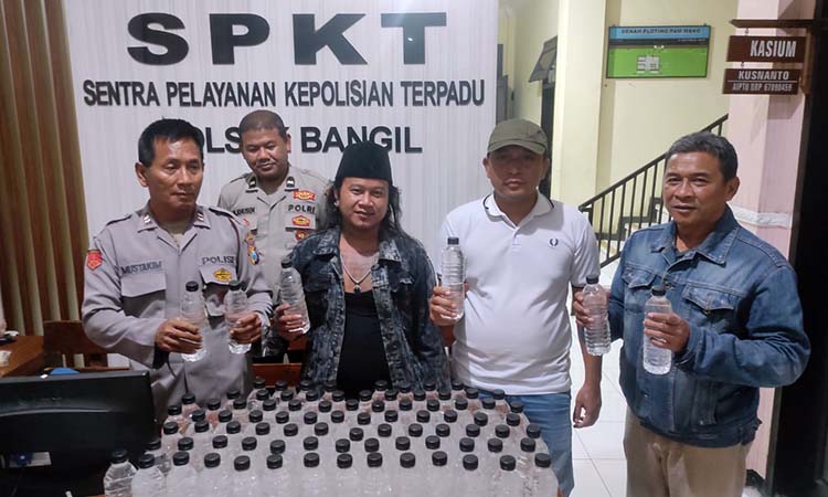 DIAMANKAN: Samhori (tengah, berpeci) dan sejumlah botol arak yang diamankan dari tangannya.