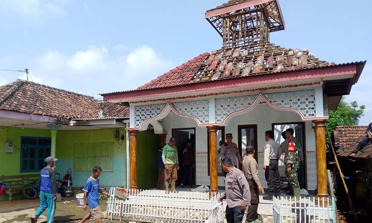 Petugas dibantu warga saat gotong royong membersihkan puing-puing reruntuhan musala di desa setempat yang rusak usai tersambar petir. (Istimewa)