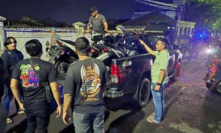 ANGKUT: Petugas kepolisian saat mengangkut motor-motor yang ditinggalkan para pembalap liar. Dari penggrebekan itu, petugas mengamankan 13 motor. Sementara pembalapnya kabur.